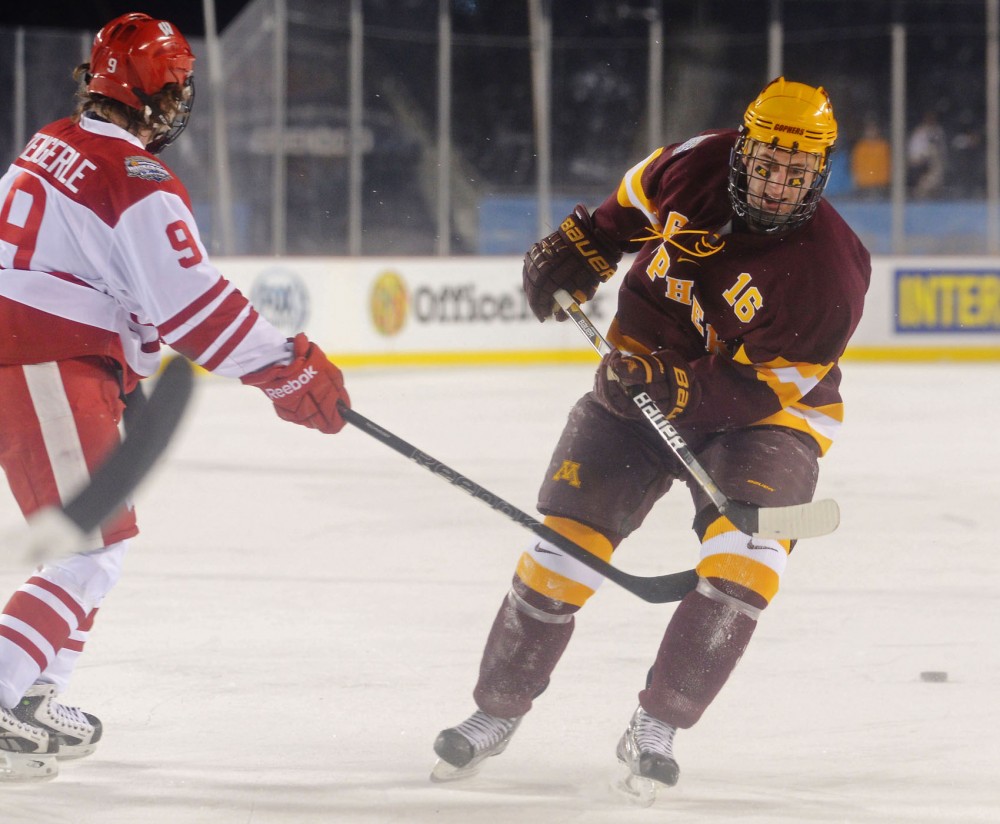 Minnesota forward Nate Condon (16) tries to block a pass from Wisconsin forward Mark Zengerle on Sunday at Soldier Field in Chicago. The Badgers beat the Gophers 3-2.