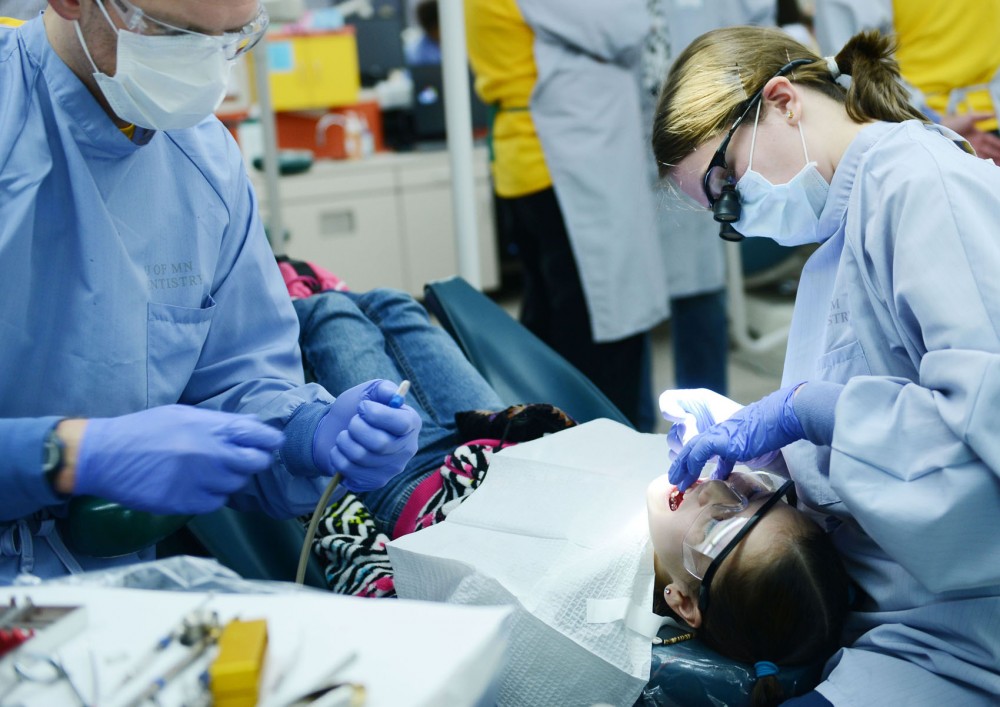 Dental students Mike Longlet and Aimee Endean clean patient Cherish Hendersons teeth Saturday, Feb. 2, 2013, at Moos Tower.
