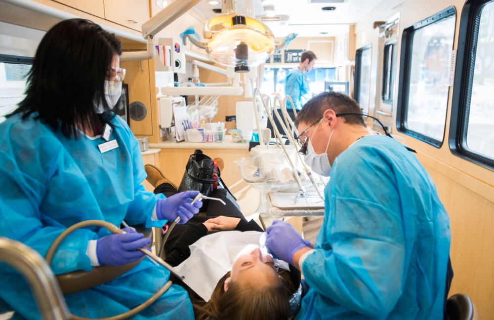 Dental assistant Molly Rogers, left, and fourth-year dentistry student Bill Johnson work on a patient at the UCare Mobile Dental Clinic on Wednesday, Feb. 20, 2013, in Diamond Lake, Minn. The clinic, in operation since 2002, provides treatment to UCare patients that might otherwise have less access to dental care.