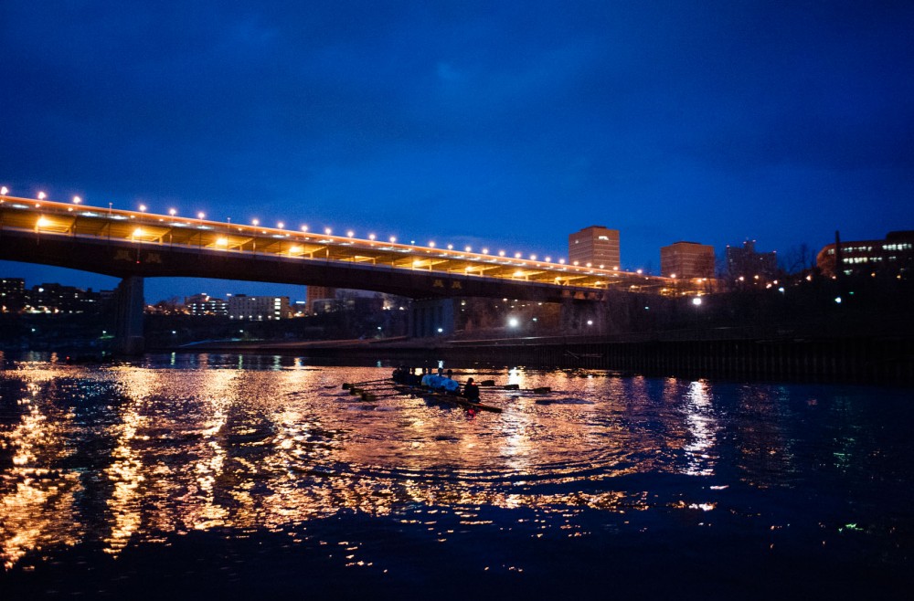 The mens club crew practices on the Mississippi River under the Washington Avenue Bridge.