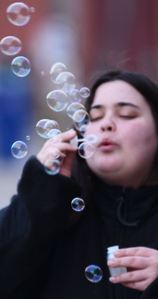 MCTC student Kelsey Weitzel blows bubbles while she waits for her bus to take her to class.