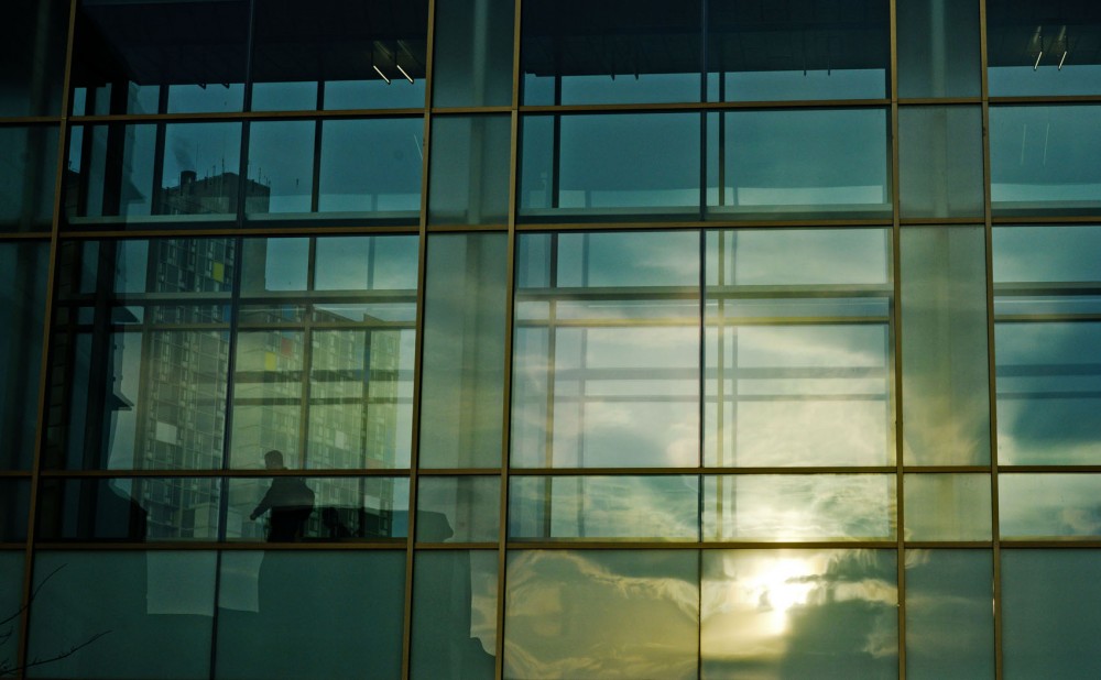 A man crosses the skyway connecting Carlson School of Management and Hanson Hall at sunrise. 