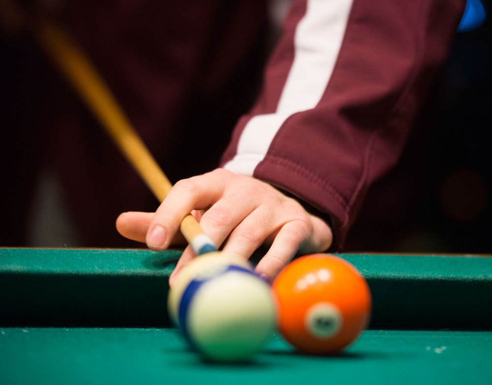 Middle East and Islamic Studies senior Luke Johnson lines up a shot during a game of pool at Sportys Pub and Grill in Como.
