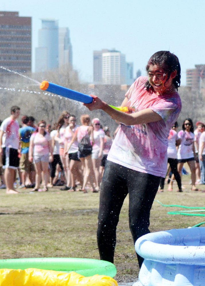 Preeya Bhakta sprays water at her friends at the Holi festival of colors on Saturday, April 27, 2013, at the East River Flats.