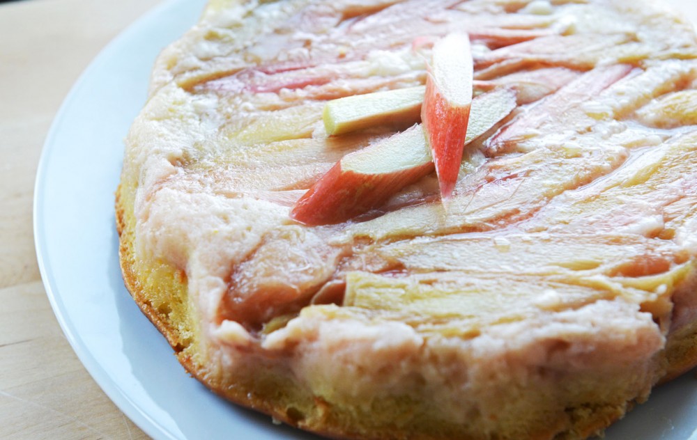 A sweet rhubarb cake with fresh rhubarbs, cake batter, and a crumb topping bottom. 