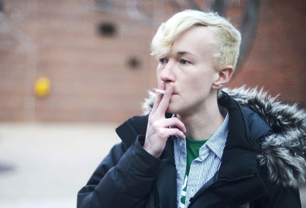 A University of Minnesota residential hall tenant stops for a smoke break in front of Territorial Hall on Saturday, May 4, 2013.