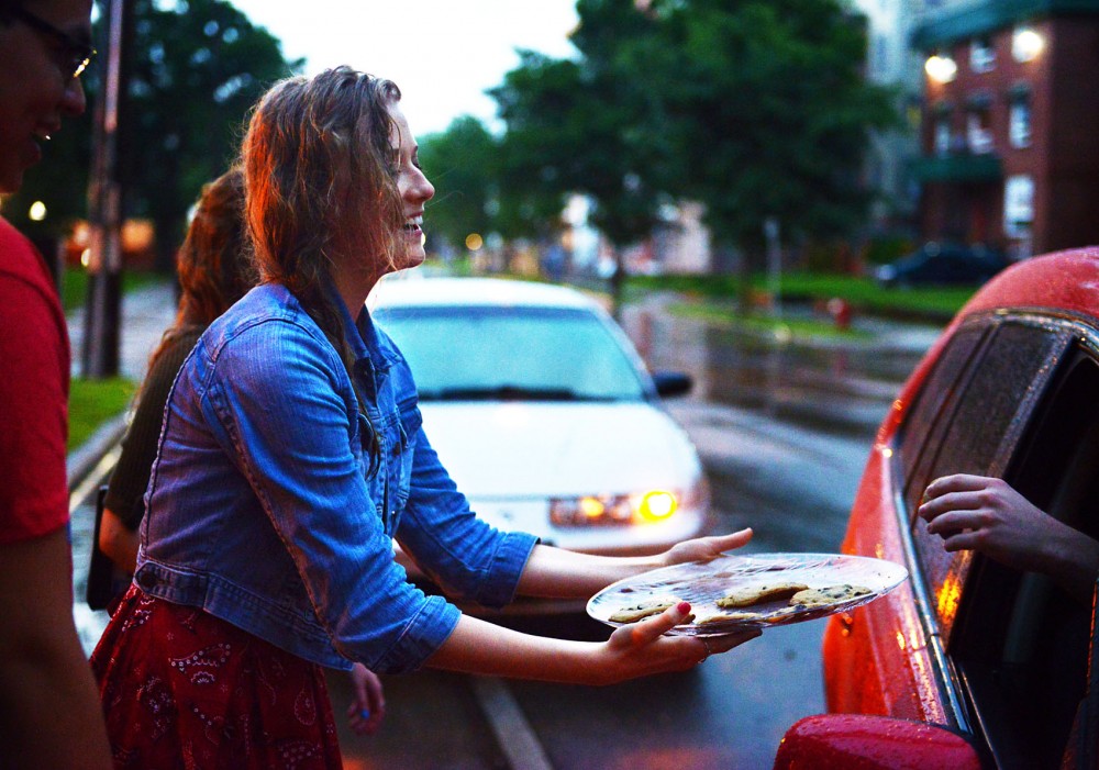 The Church of Jesus Christ of Latter-day Saints member Victoria Paider hands out cookies to stalled cars after the rainstorm caused flash floods along University Avenue on Friday, June 21, 2013 outside the Minneapolis LDS Institute of Religion.