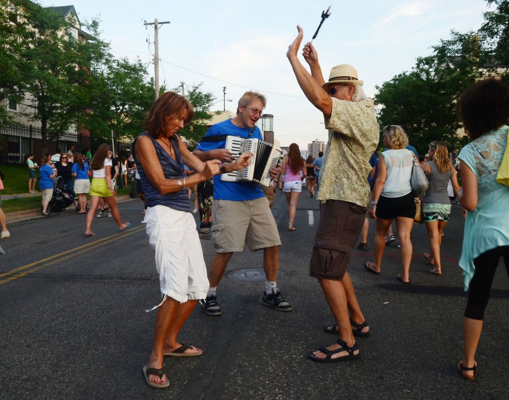 People dance in the streets while a man plays accordion, Friday evening at Basilica Block Party in Minneapolis.