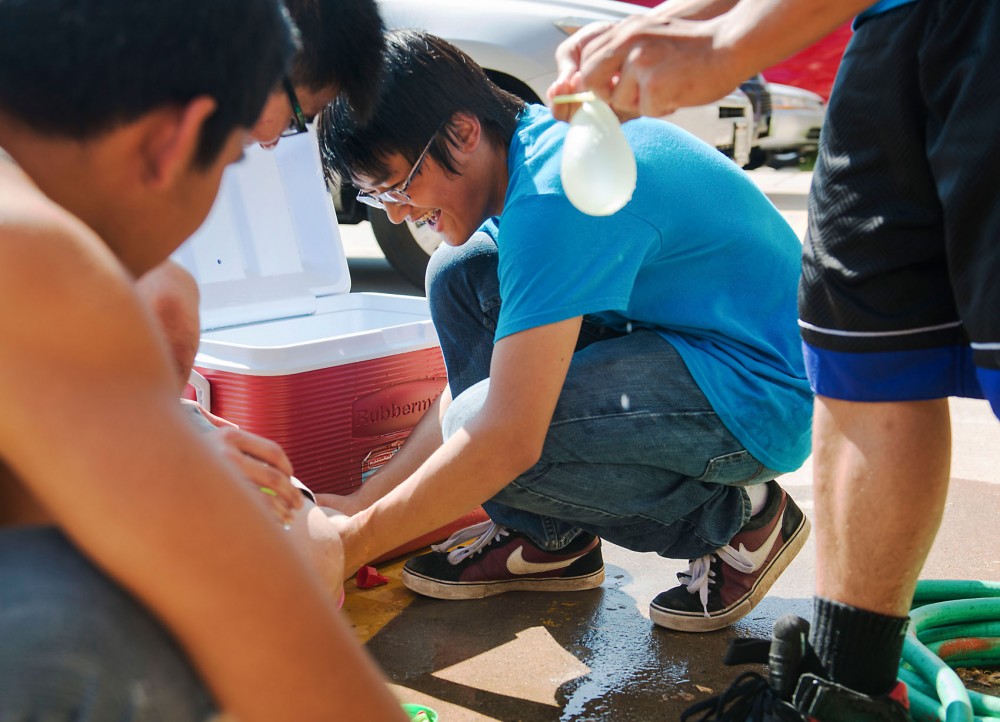 Second year PSEO student and high school senior Brandon Luu, center, fills up water balloons with other members of their student group as a part of Asian-American Student Unions picnic, Friday afternoon outside Comstock Hall. Luu was introduced to AASU by a family member and is now an outreach officer for the student group.