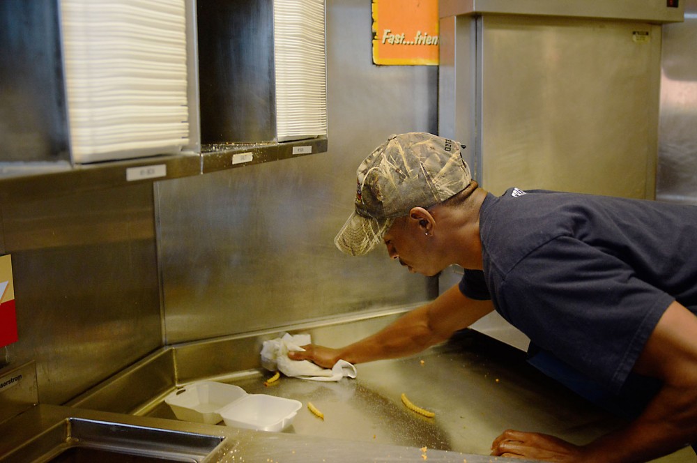 Dorian McCoy wipes down counters at Raising Canes Chicken Fingers in Stadium Village on Friday.