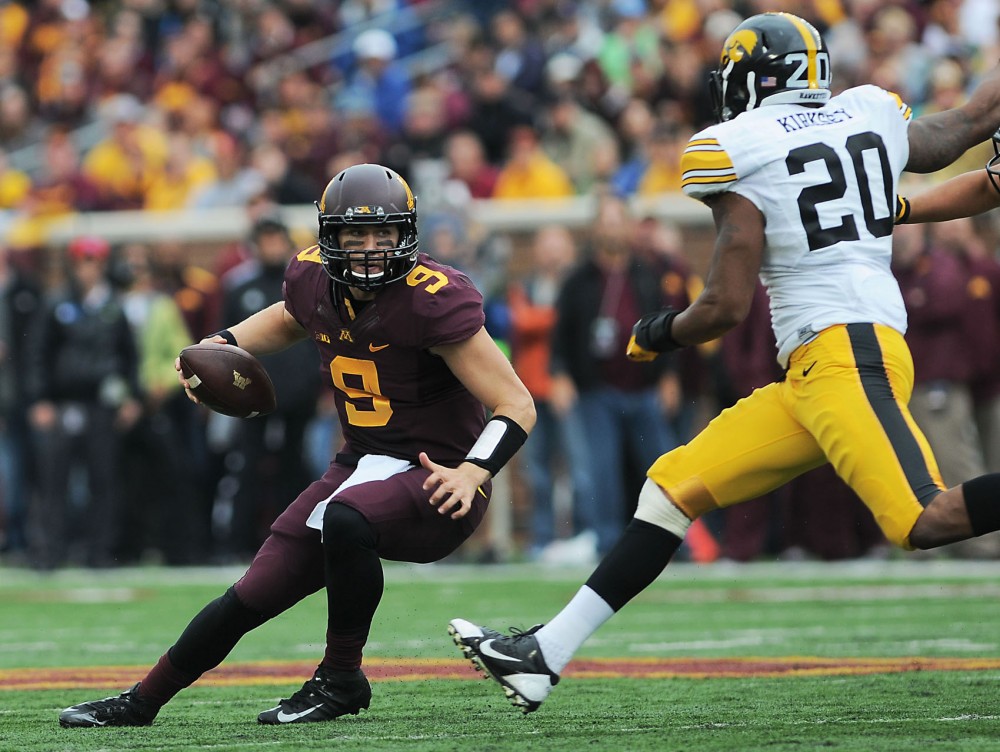 Minnesota quarterback Philip Nelson scrambles to avoid a Hawkeye tackle on Saturday afternoon at TCF Bank Stadium. 