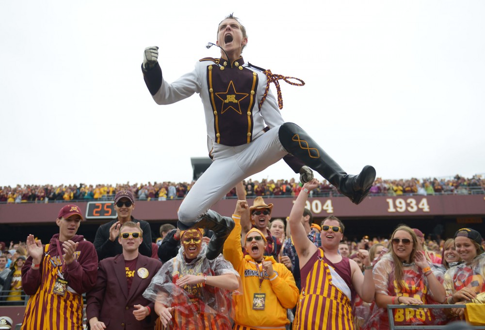 Minnesota marching band drum major Brandon Folkes jumps off the stands before the homecoming game against the Hawkeyes on Saturday at TCF Bank Stadium. 