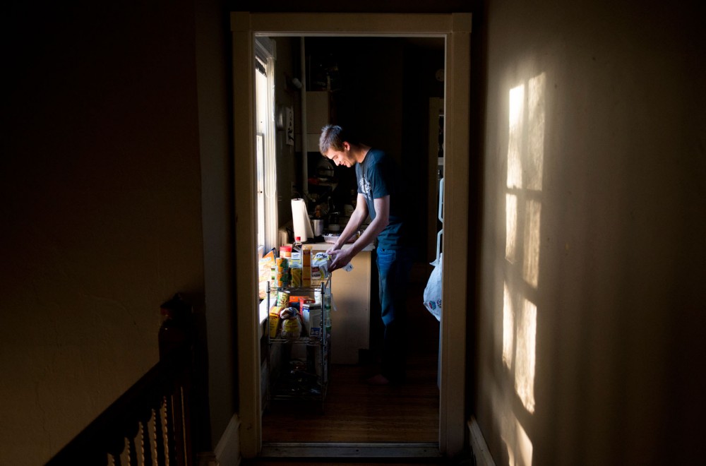 Senior communications major Seth Zimmermann makes himself dinner on Tuesday at his house in Dinkytown.