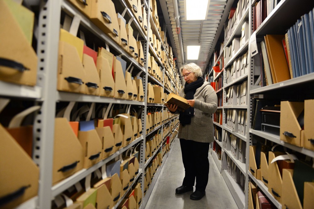 Lisa Von Drasek, curator in the Childrens Literature Research Collections at Elmer L. Andersen Library, looks through rows of books in one subset of the underground archive. 