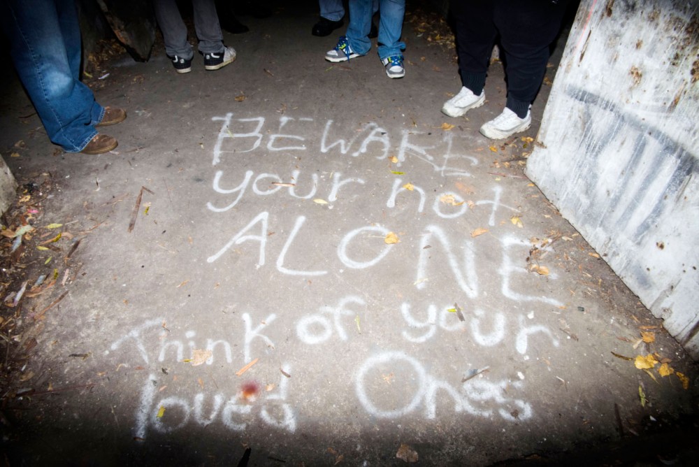 The group Supernatural Investigators of Minnesota stands around spray paint on the ground of one of abandoned buildings on the land in Faribault, Minnesota. 