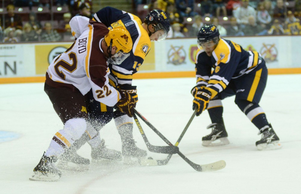 Minnesota forward Travis Boyd fights for the puck against Lethbridge on Saturday, Oct. 5, 2013, at Mariucci Arena.