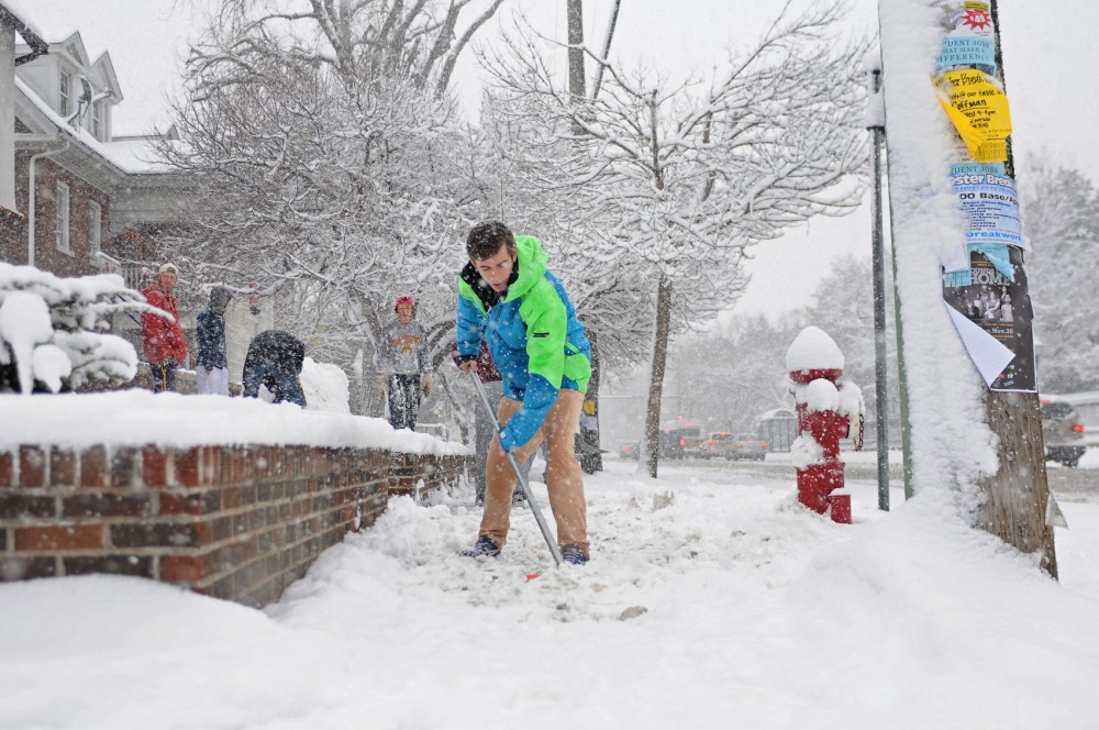 Freshman Joey Ryan shovels off the sidewalk in front of his fraternity house Sunday, Dec. 9, 2012.