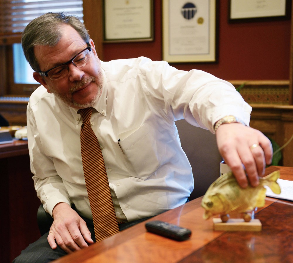 University president Eric Kaler with a piranha he got in Brazil while doing research there at his office in Morrill Hall on Friday. 