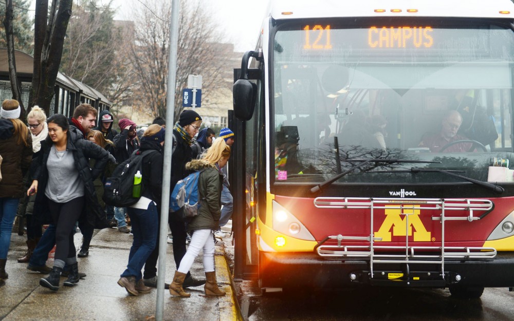 University students get on and off the campus connector bus on Tuesday.  On Dec. 7 2013, the campus connectors, along with other metro transit buses, will resume bus service on Washington Avenue for the first time since May 2011.
