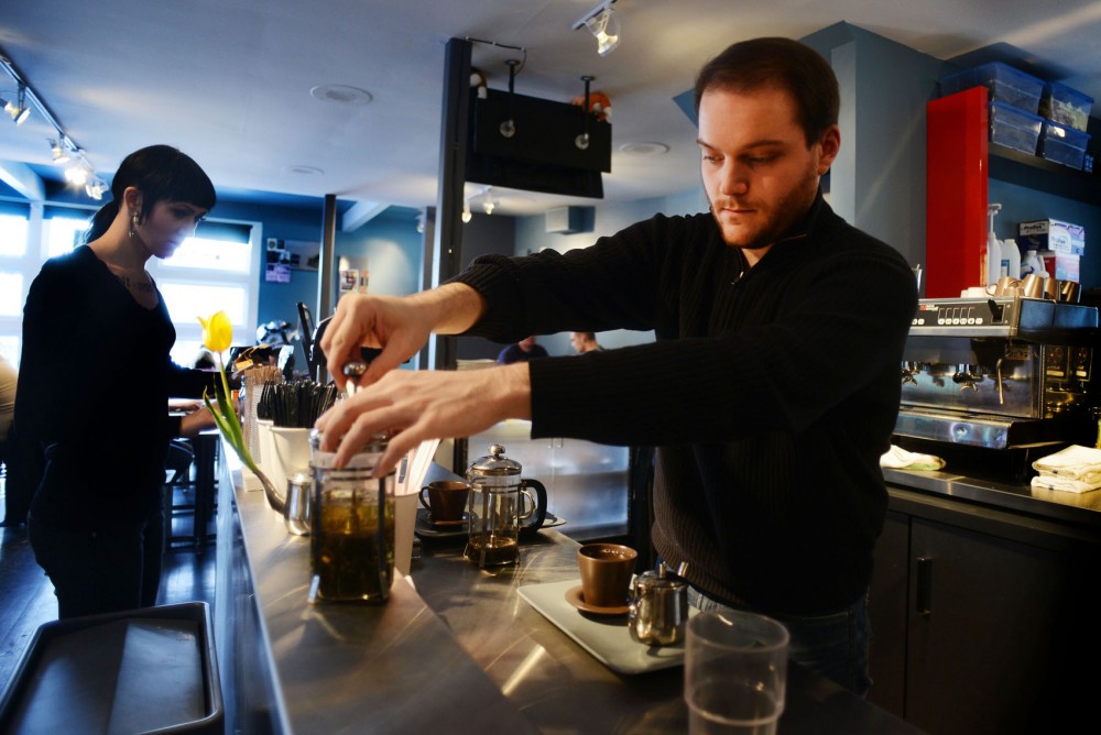 Leather & Latte co-owner Luke Wallrich brews tea in a French press at the Uptown coffee shop on Sunday. Leather& Latte opened this location in October after receiving funding from Kickstarter.