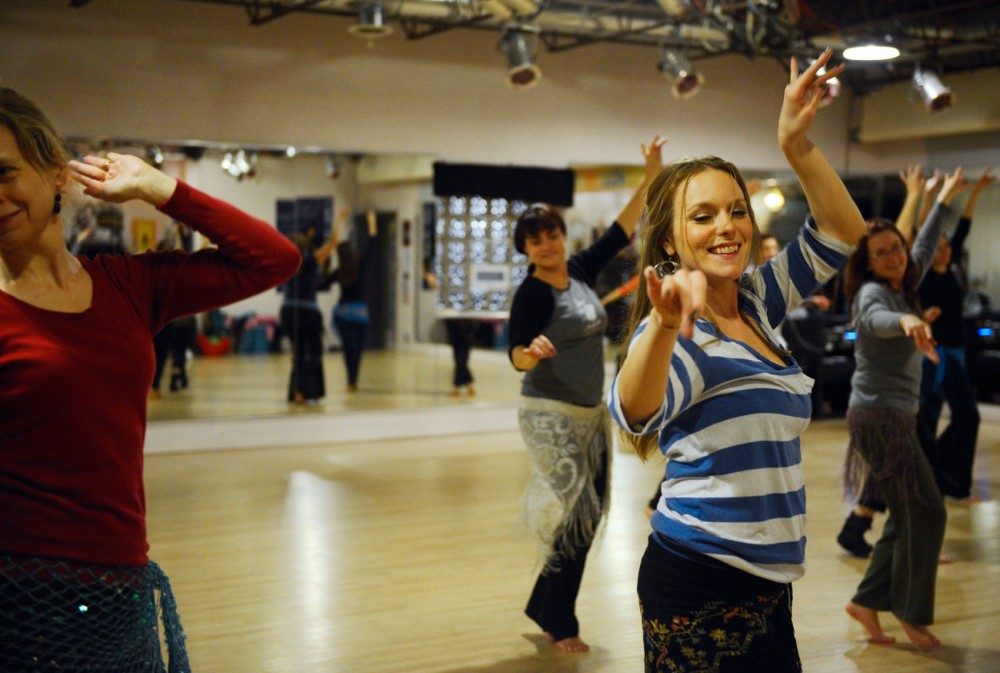 Jenna Neher, right, practices her Middle Eastern dancing skills at a belly dancing class taught by Cassandra Shore at the Jawaahir studio on Tuesday night. 