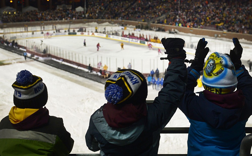 Hockey City Classic attendees Will Rogalski, Wyatt Rogalski and Kaden Eicher cheer on the Gophers against the Buckeyes during the 2014 Hockey City Classic at TCF Bank Stadium on Friday.