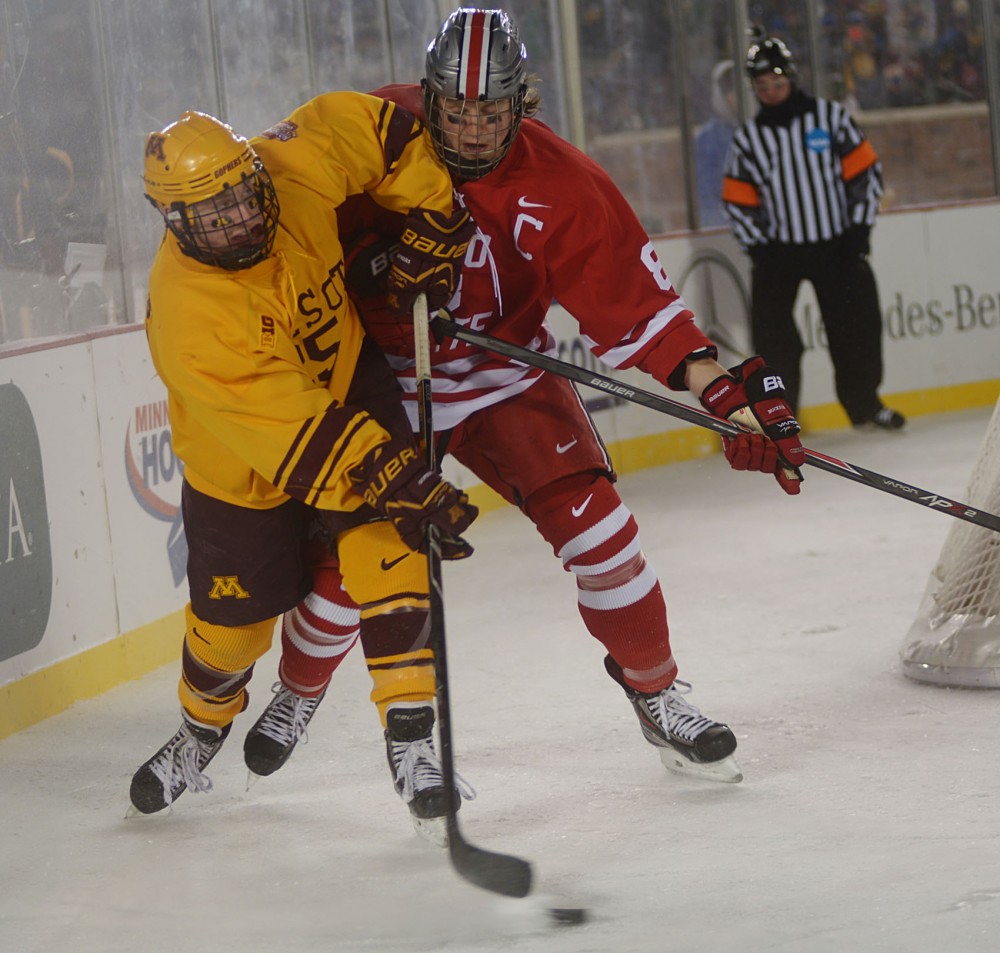 Minnesota forward Justin Kloos attempts to pass against the Buckeyes on Friday at the 2014 Hockey City Classic at TCF Bank Stadium. 
