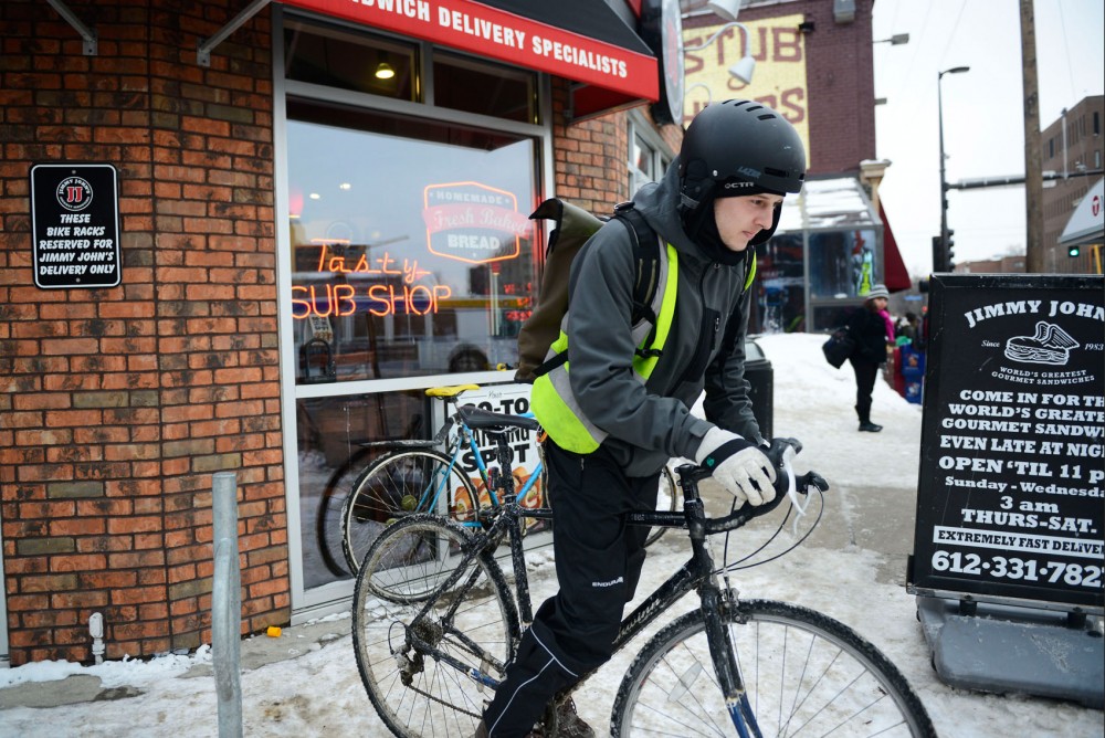 Jimmy Johns employee Derek Cousins leaves on his bike for a delivery on Monday, March 3, 2014 in Stadium Village.