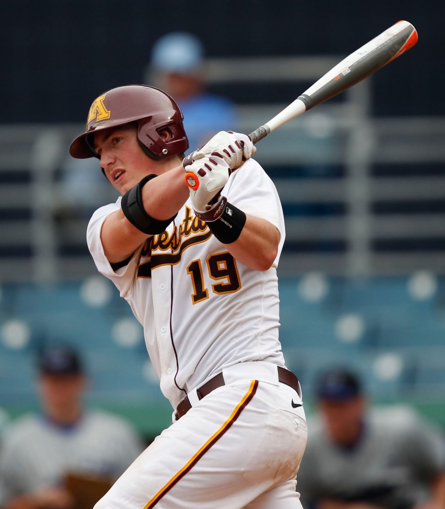 Gophers Austin Athmann swings at the ball on Friday, Feb. 21, 2014. 
