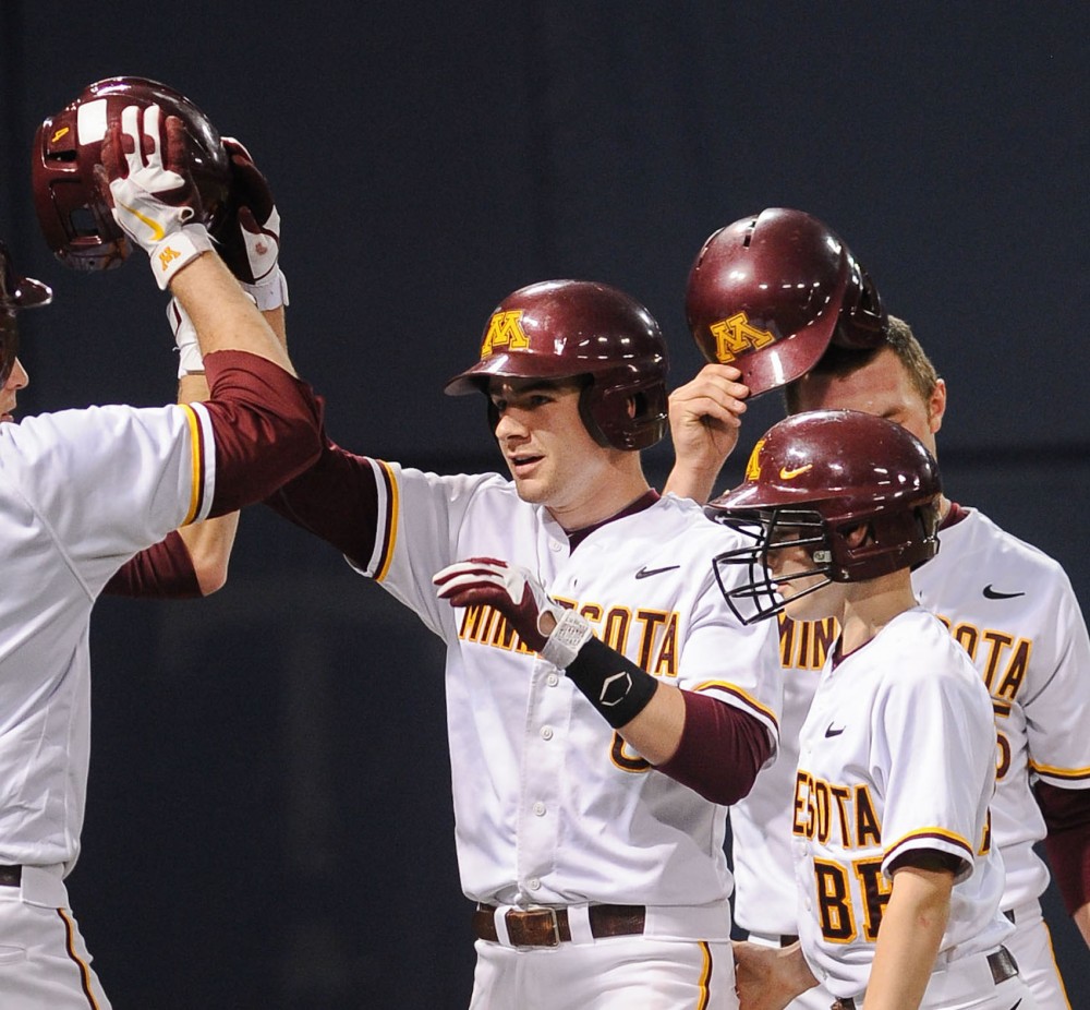 Minnesota catcher Matt Halloran celebrates with his team after hitting a two-run home run against Iowa on Friday, April 27, 2012, at the Metrodome.