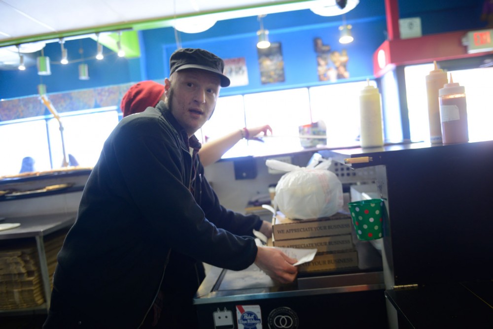 Delivery manager Nathan Nato Coles collects orders in preparation to deliver at Mesa Pizza on Friday.  