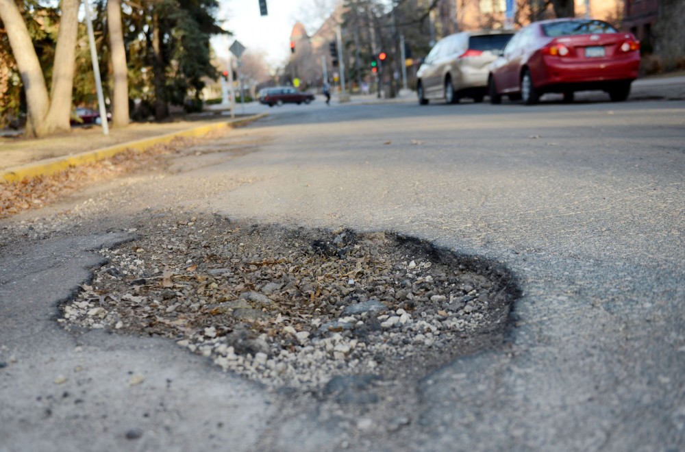 One of the many potholes that cars attempt to avoid hitting on Pillsbury Drive Southeast on the Universitys East Bank on Thursday.