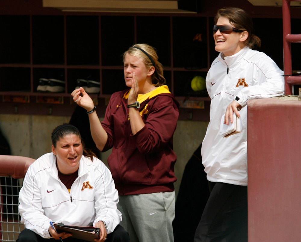 Minnesota head softball coach Jessica Allister, right, volunteer assistant Dannie Skrove and pitching coach Piper Ritter cheer from the dugout May 5, 2013, against Indiana. Allister has led the Gophers to three straight seasons with 30 or more wins since her arrival in 2010.