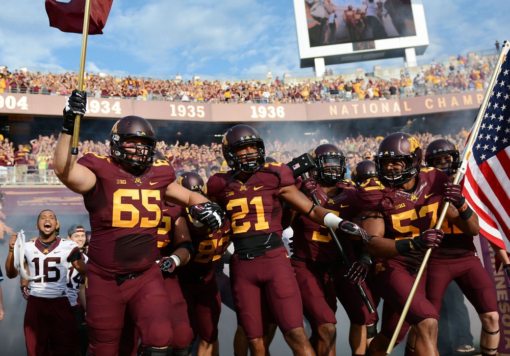 Minnesota players charge onto the field before the start of the Gophers season opener against UNLV on Thursday at TCF Bank Stadium.