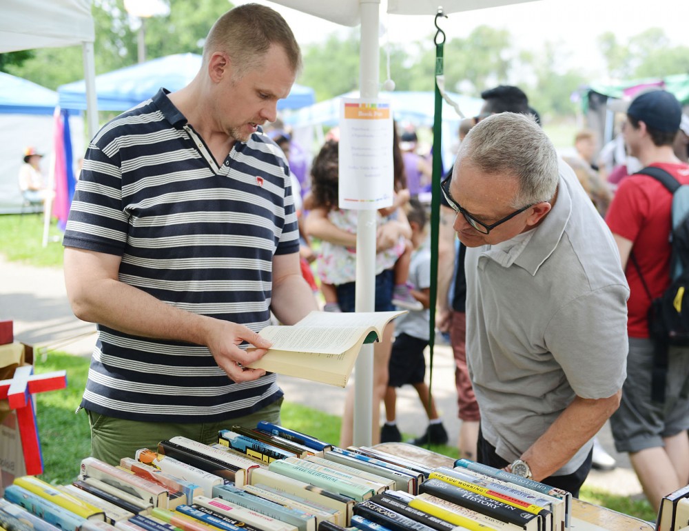 University professor Benjamin Munson and his partner Kevin Burk look through used books at the Twin Cities Pride festival Saturday.  Munson and Burk received domestic partnership benefits before they got married last summer.  
