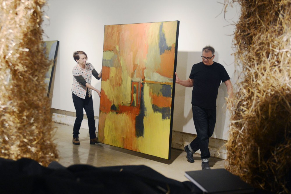 Minneapolis sculptor Rebecca Krinke and painter Duane Ditty carry a painting while installing their new exhibit Incident at the Rosalux Gallery on Monday.