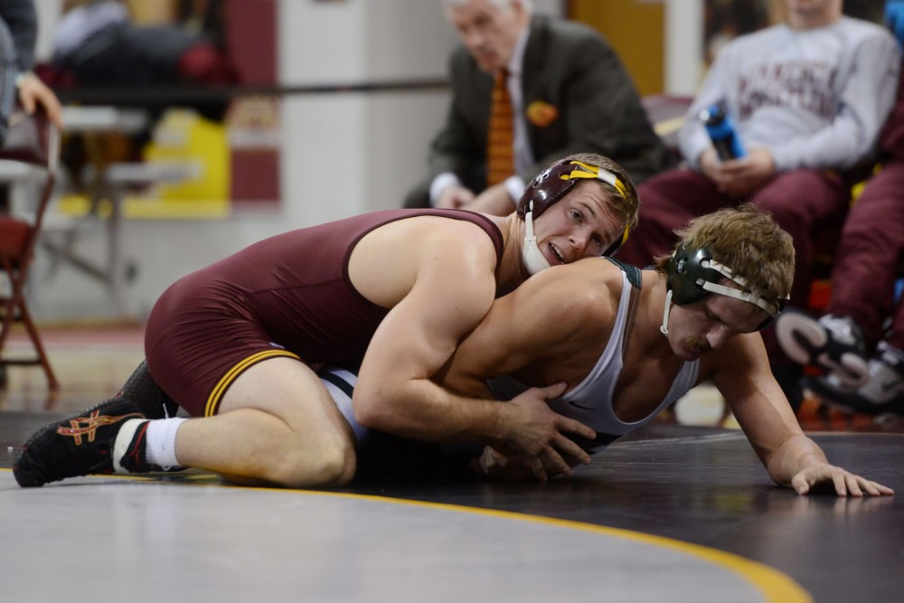 Senior Logan Storley wrestles against his opponent at the Sports Pavilion on Friday evening, where the Gophers took on Michigan State.