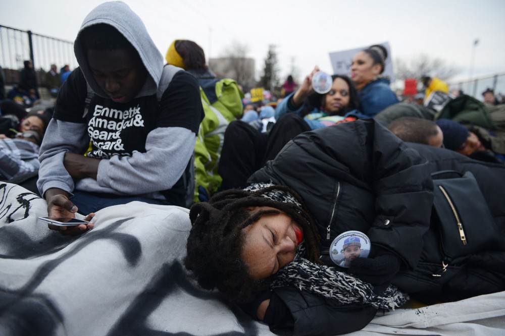 Demonstrators lay on the ground while participating in a die-in on Hamline Avenue over I-94 during Mondays march in St. Paul.