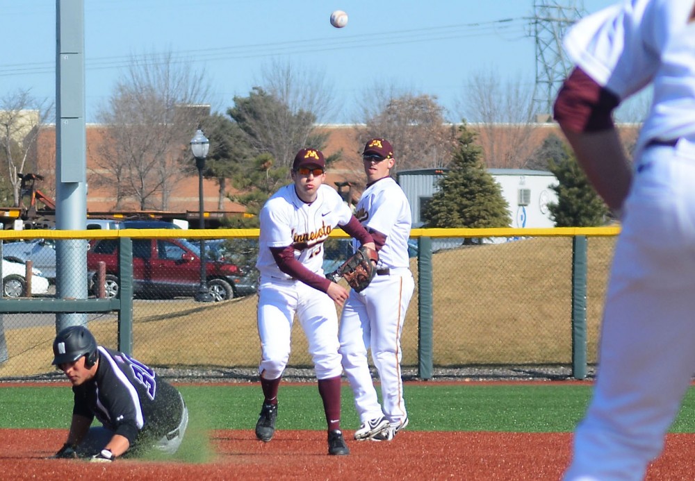 Infielder Luke Pettersen throws the ball to catcher Toby Hanson at first base during a game against Northwestern at Siebert Field on Saturday. 