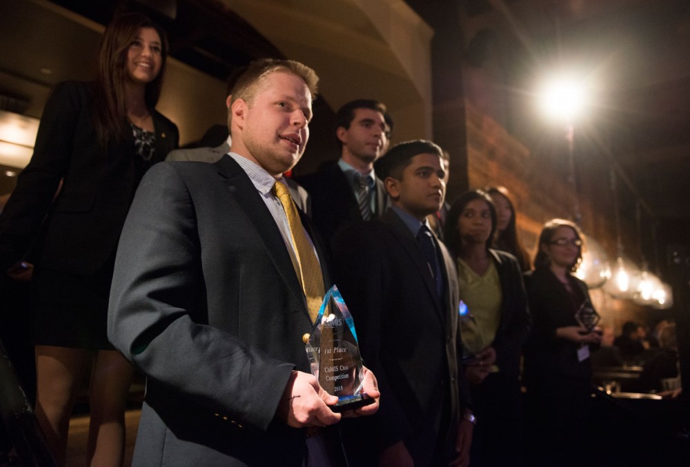 Senior Spencer Price holds his teams 1st Place trophy that the University of Minnesota was awarded in the 2015 CoMIS Case Competition during an award ceremony held at Urban Eatery in Minneapolis on Saturday evening.