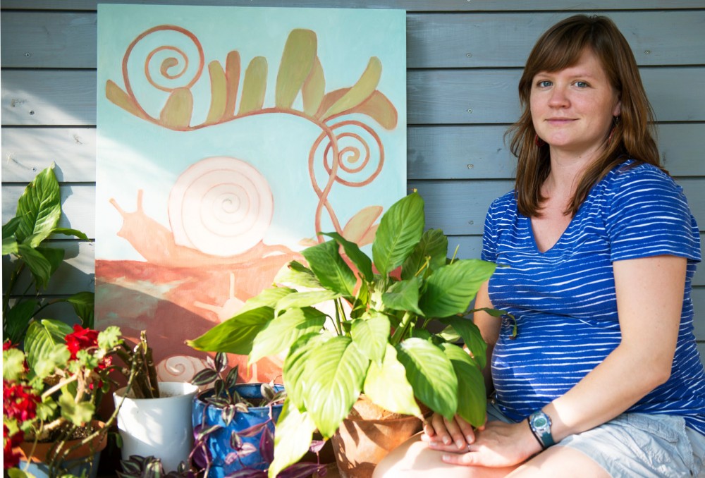 Local artist Megan Moore poses with her paintings outside her home on Monday. Moores work will be featured as a stop on the League of Longfellow Artists art crawl taking place this Saturday, September 19. 