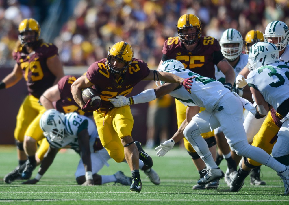 Running back Shannon Brooks pushes an Ohio defenseman aside on his way to score a touchdown at the Homecoming game in TCF Bank Stadium on Saturday where the Gophers won 27-24.