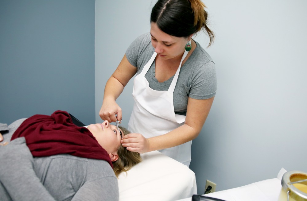Refinery co-owner Megan Smith gives Sarah Snapp an eyebrow wax. Smith says that the Refinerys variety of services and affordable prices should help give them the edge over a new competitor.