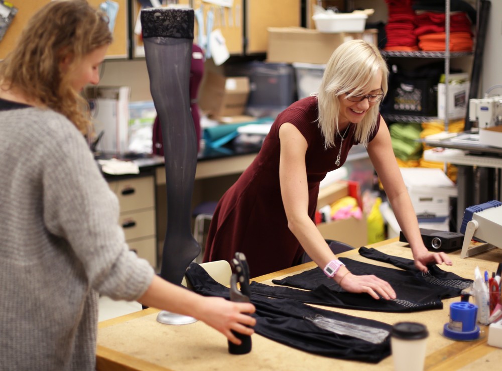 Grad students Julia Duvall (left) and Crystal Compton (right) organize several of their wearable technology garments. One of Duvall and Comptons pieces , named Brace Yourself - Worlds Sexiest Knee Brace, is a technologically advanced tight that prevents harmful knee movements by retraining the muscles. 