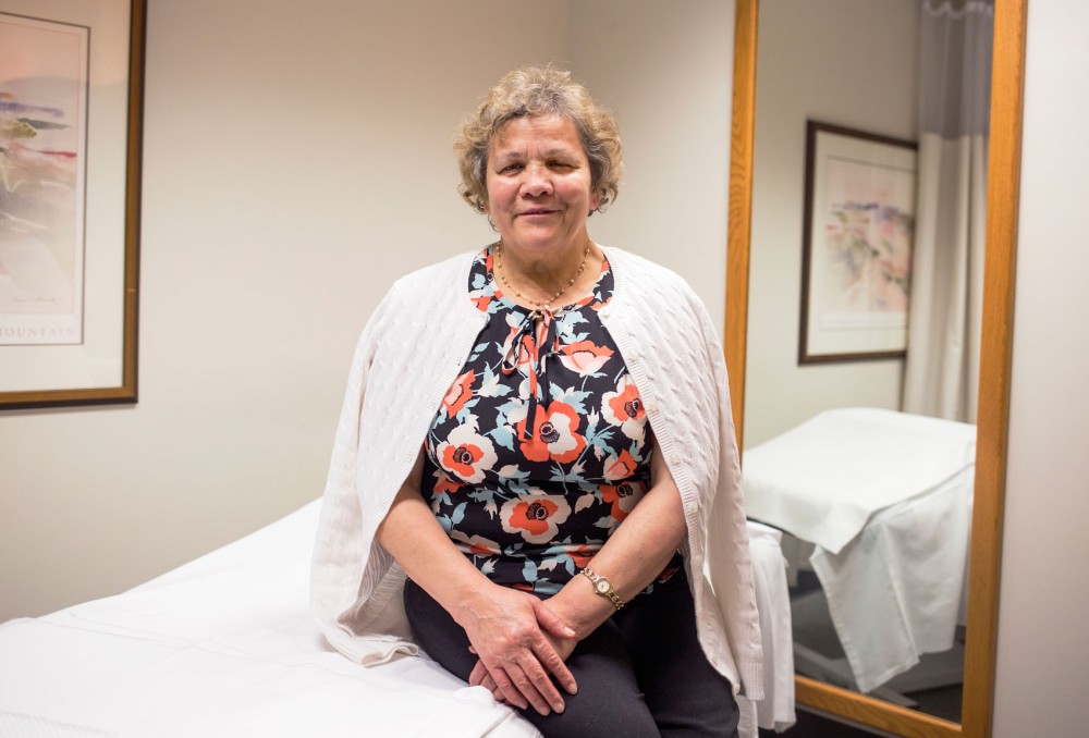 Coca-Iona Vladislav, a professional massage therapist at Boynton Health Service, sits posed on the massage table where she tends to her patients on Friday.