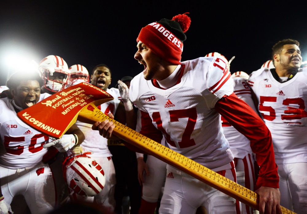 The University of Wisconsin-Madison football team celebrates, claiming Paul Bunyans Axe for the twelfth consecutive year at TCF Bank Stadium on Saturday where the Gophers fell to the Badgers 31-21.
