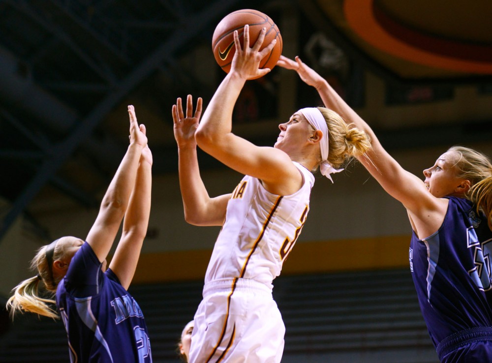 Carlie Wagner manages to shoot in between two Maine defenders on Nov. 20 at Williams Arena.