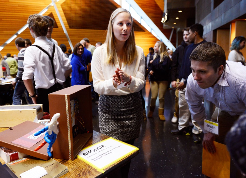 Mechanical engineering student Kelsey Harper presents RHONDA, a robotic hand capable of playing Rock, Paper, Scissors to judge Jesse Geroy during the annual Mechanical Engineering Robot Show in the McNamara Alumni Center on Monday afternoon. 