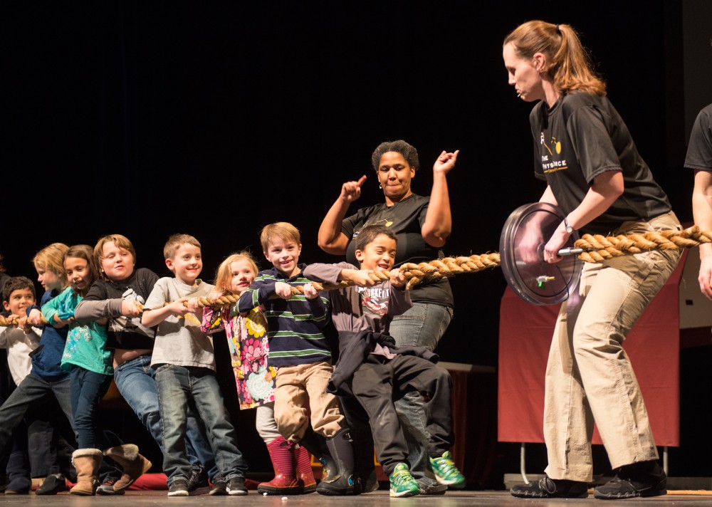 Children attempt to tug plates apart at the Physics Circus in Northrop Auditorium on Thursday. The event, hosted by the Physics Force, aimed to entertain and educate children through a variety of physical science performances.