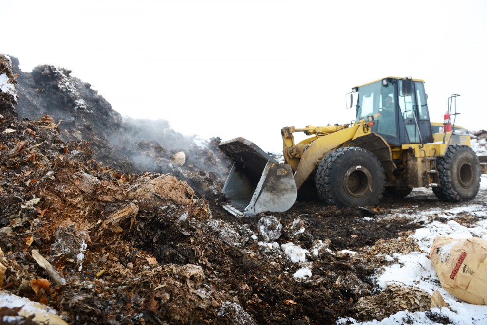 A front-loader collects decomposing leaves to be mixed with compost materials, forming mulch for later resale at the Specialized Environmental Technologies composting site in Rosemount on Wednesday.